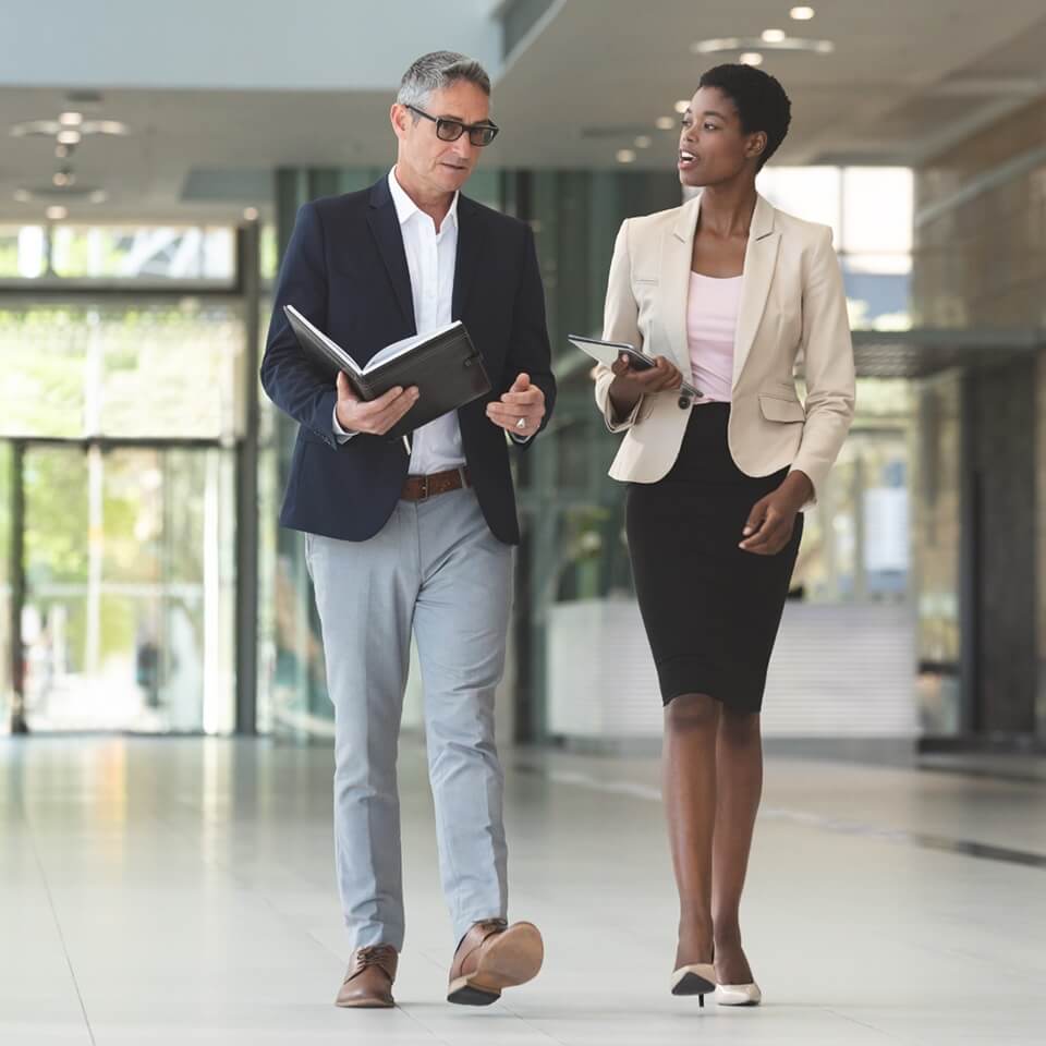 a man and woman walking through business setting