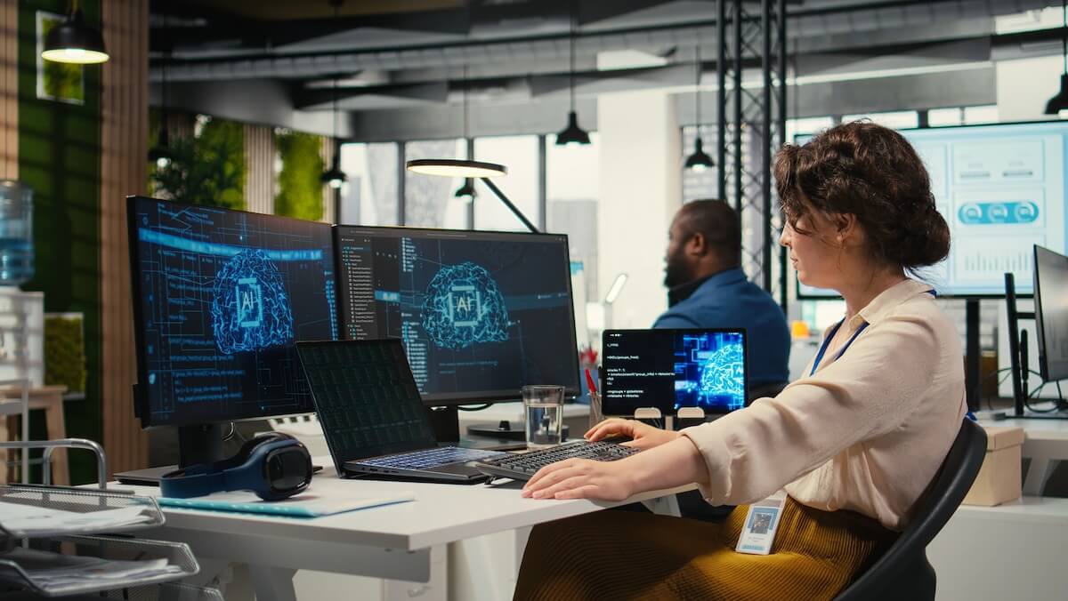 Person using AI-powered data visualization tools on a laptop with abstract digital graphics in the background.